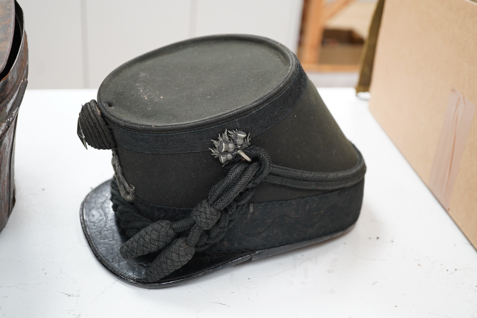 A Victorian tin cased Scottish Rifles officer's shako by Cater & Co. Pall Mall, London, with cap badge for the Cameronians, Applied plaque to lid engraved R. Robertson Esq. 2nd Scottish Rifles. Condition - fair to good,